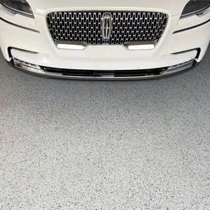 White Ford Lincoln on a gray full-flake epoxy and polyaspartic-coated garage floor.