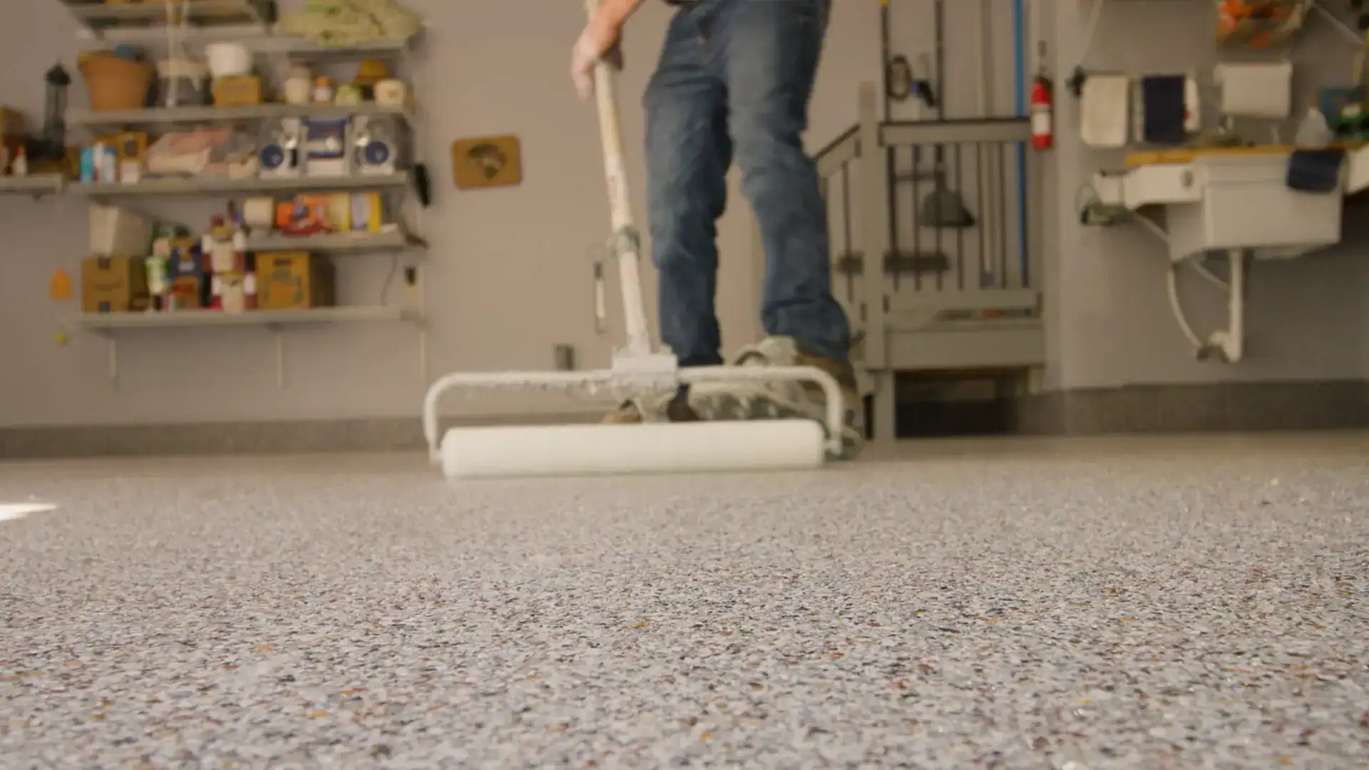 Garage Floor Coating Rolling on the clear top coat in a garage
